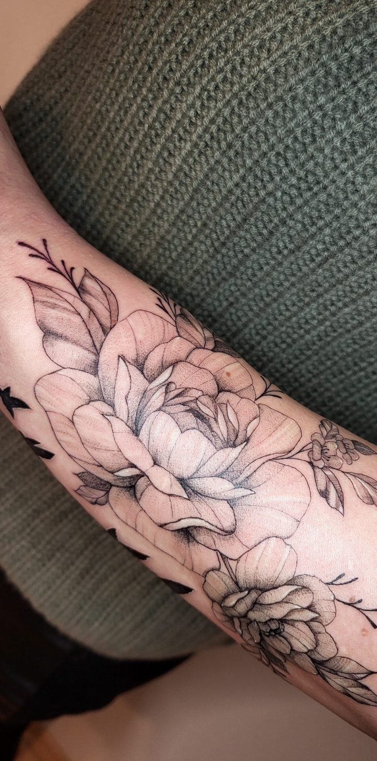 Tattoo eines Blumendesigns auf dem Unterarm mit detaillierten Rosenmotiven.