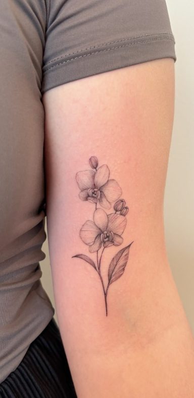 Tattoo eines floralen Motivs auf dem Oberarm.
